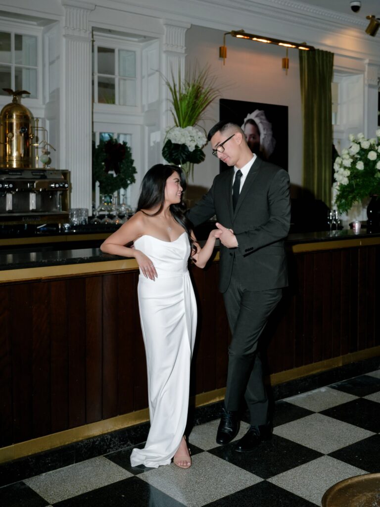 Couple standing together at a cocktail bar during an editorial engagement session with elegant indoor engagement photography